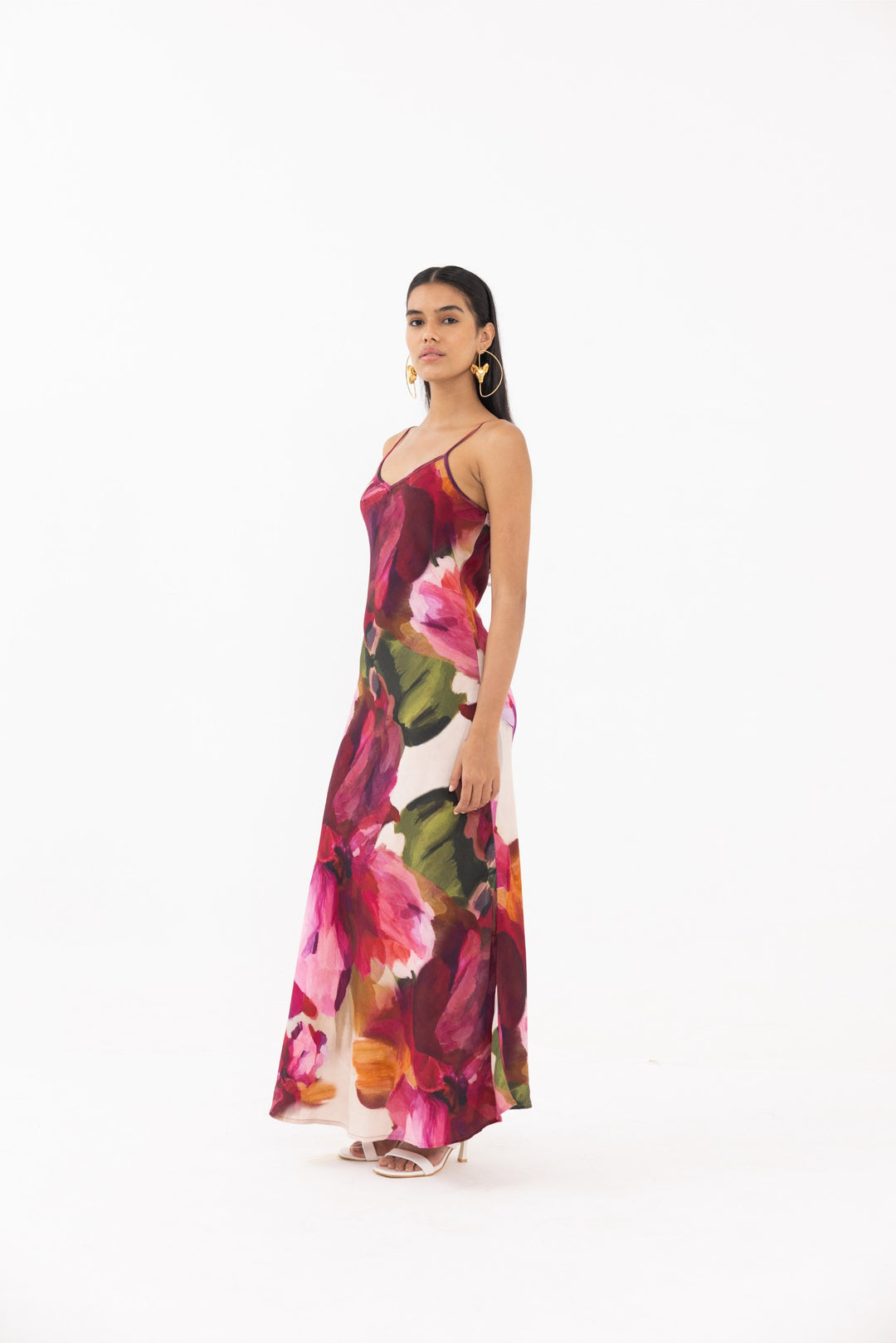 Thr3letter Zahra Sleeveless Floral Slip Dress - A floor-length dress with a sleek slip silhouette and a vibrant, abstract floral print in shades of pink, red, and green.