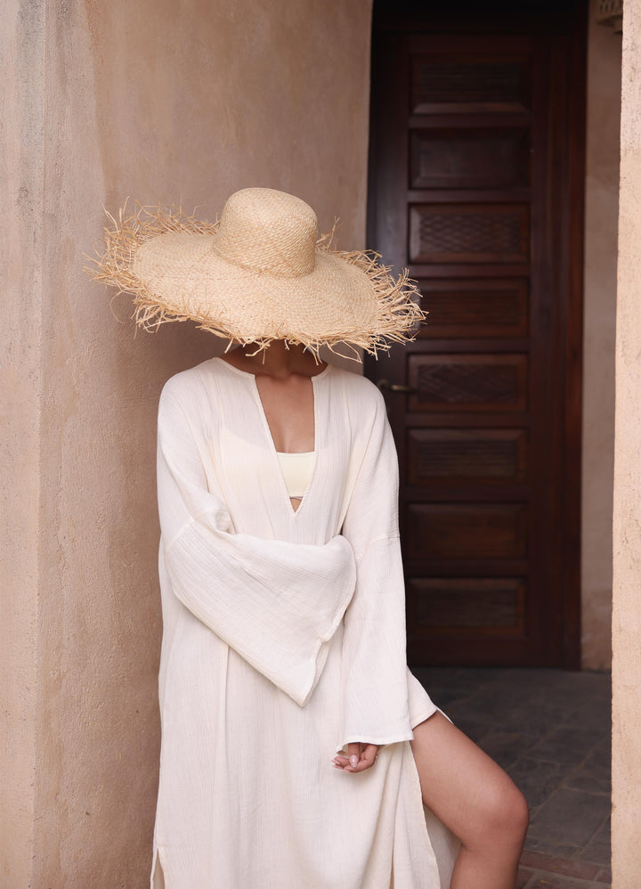 Thr3letter's Kiaan Kaftan in a neutral almond color, a blend of seersucker and organic cotton for comfort.