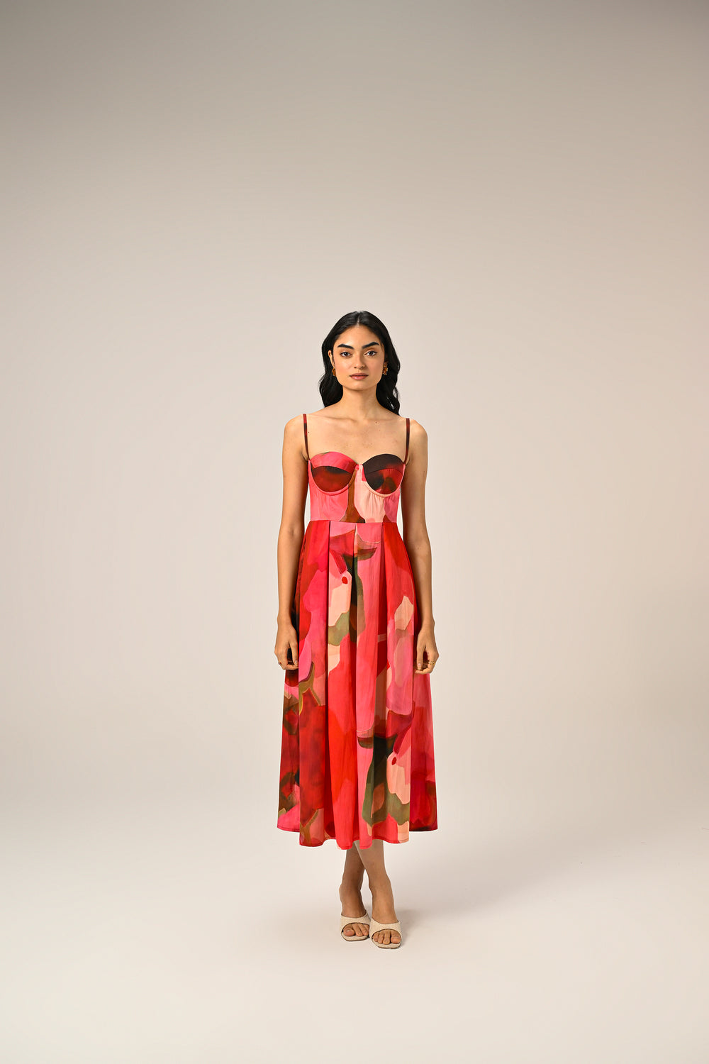 Women's pink and red abstract floral midi dress featuring a structured sweetheart bodice, spaghetti straps, and flared skirt.